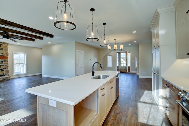 kitchen featuring sink, an island with sink, pendant lighting, beam ceiling, and dark hardwood / wood-style floors