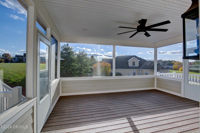 unfurnished sunroom featuring ceiling fan