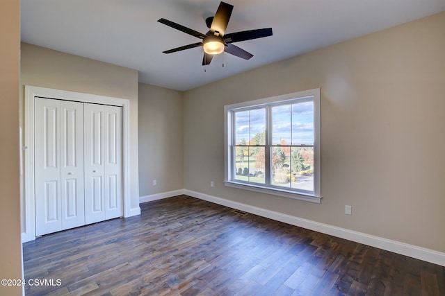 unfurnished bedroom featuring dark hardwood / wood-style floors, a closet, and ceiling fan