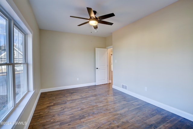 spare room featuring dark hardwood / wood-style floors, a healthy amount of sunlight, and ceiling fan