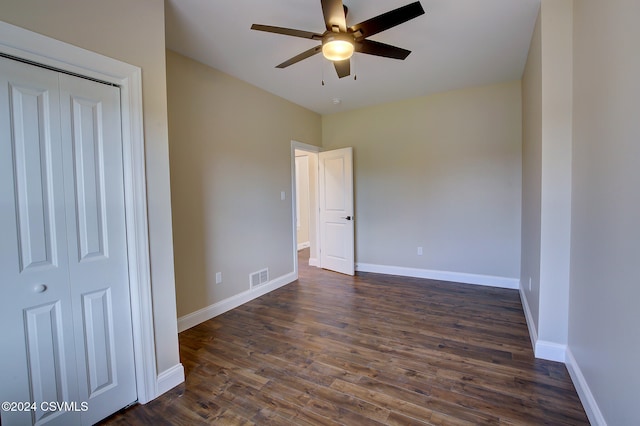 unfurnished bedroom featuring a closet, ceiling fan, and dark hardwood / wood-style flooring