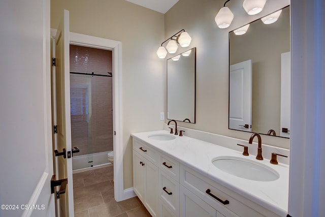 bathroom with a shower with door, vanity, toilet, and tile patterned flooring