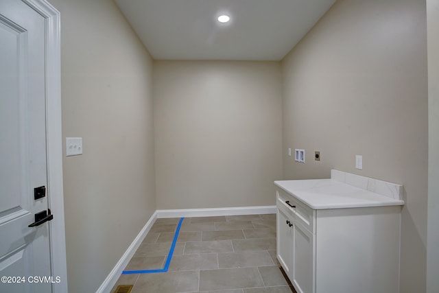 clothes washing area with hookup for an electric dryer, hookup for a washing machine, cabinets, and light tile patterned floors