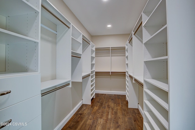 walk in closet with dark wood-type flooring