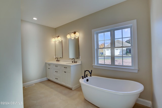 bathroom featuring vanity, tile patterned floors, and a washtub