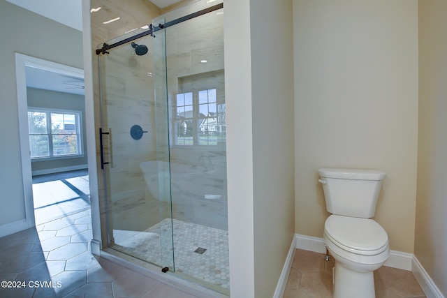 bathroom featuring toilet, walk in shower, and tile patterned flooring