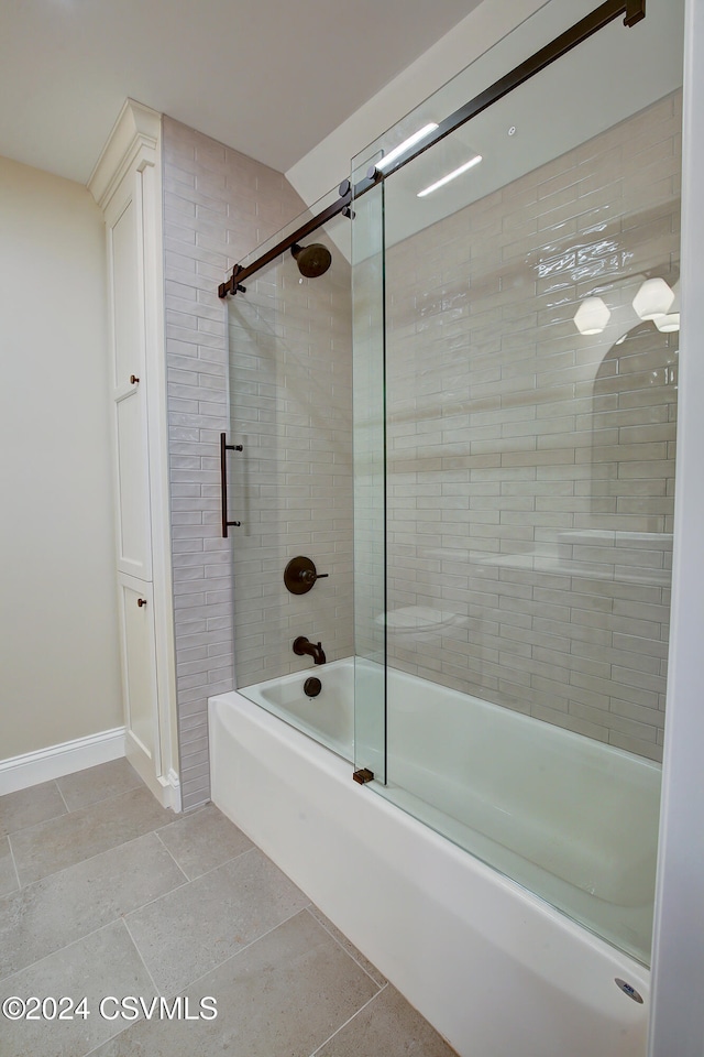 bathroom featuring combined bath / shower with glass door and tile patterned flooring