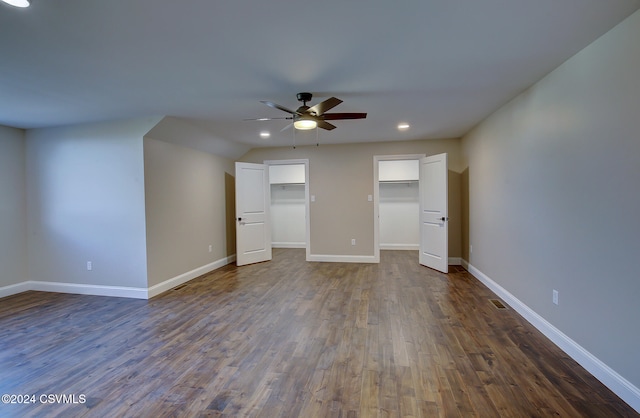 unfurnished bedroom featuring a spacious closet, ceiling fan, a closet, and dark hardwood / wood-style flooring