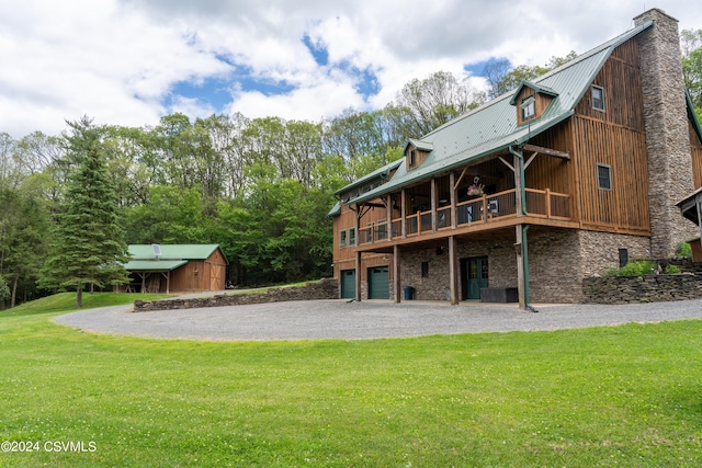 back of property with a lawn, a garage, and a storage shed