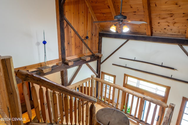 staircase with vaulted ceiling with beams, ceiling fan, and wooden ceiling