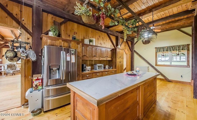 kitchen featuring radiator, light hardwood / wood-style flooring, wooden ceiling, stainless steel fridge with ice dispenser, and a center island