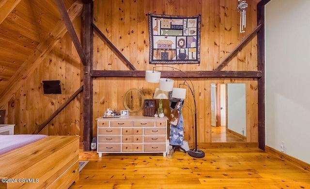 interior space with hardwood / wood-style flooring and wooden walls