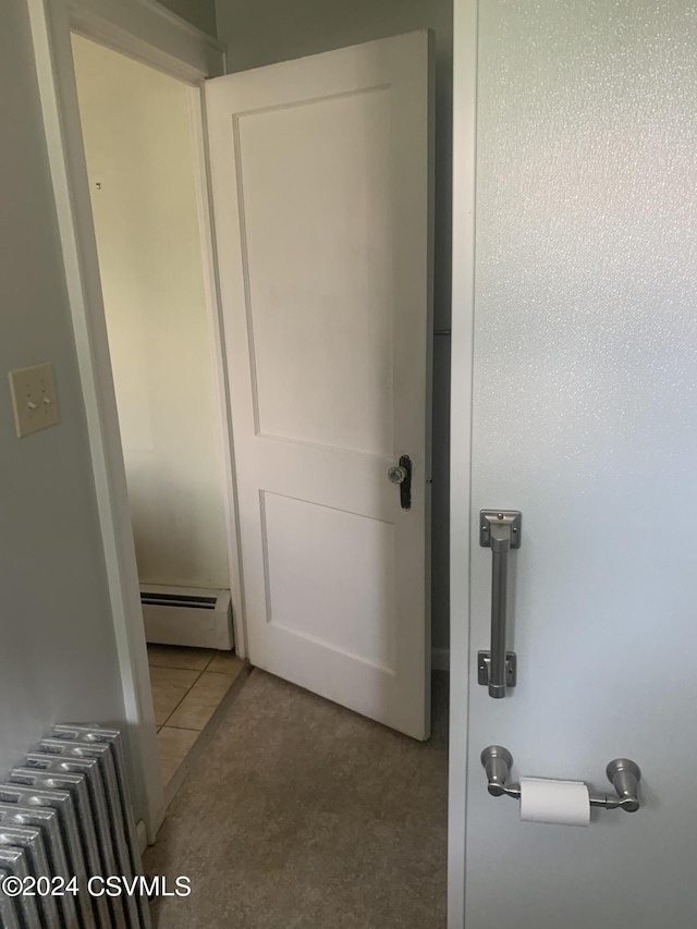 hallway featuring light tile patterned flooring, baseboard heating, and radiator