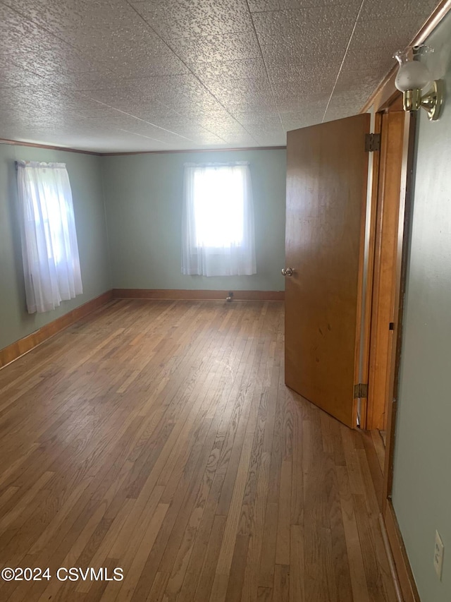 unfurnished room featuring hardwood / wood-style flooring and a textured ceiling