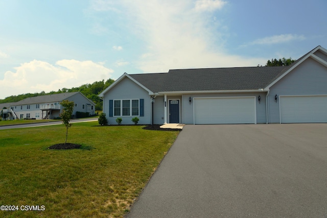 ranch-style house featuring a front yard, driveway, and an attached garage