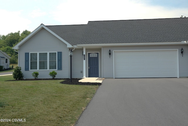 view of front of property with a front lawn, an attached garage, and aphalt driveway