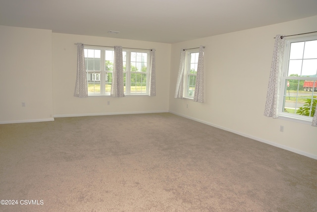 carpeted spare room featuring baseboards