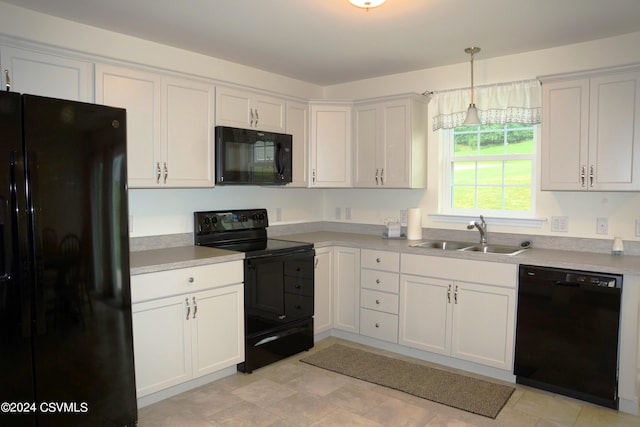 kitchen featuring black appliances, a sink, white cabinetry, and pendant lighting