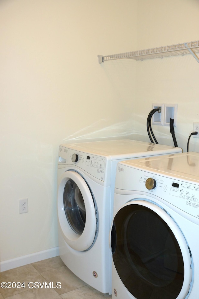 laundry area featuring laundry area, independent washer and dryer, baseboards, and light tile patterned floors