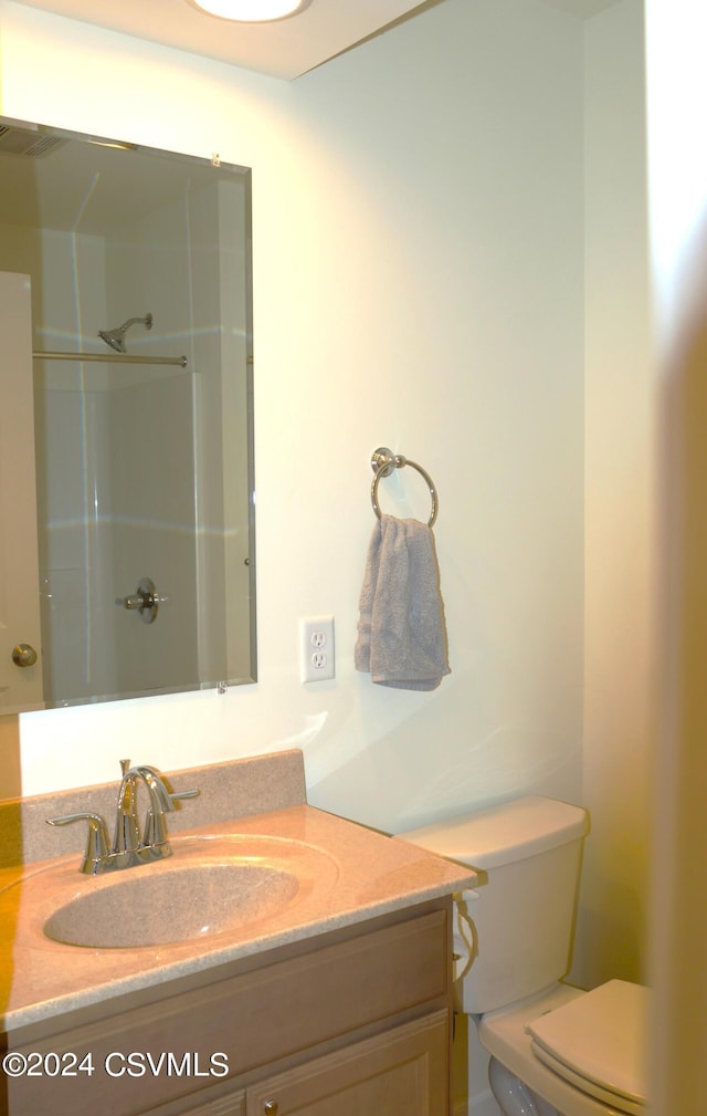 bathroom with a shower, vanity, and toilet