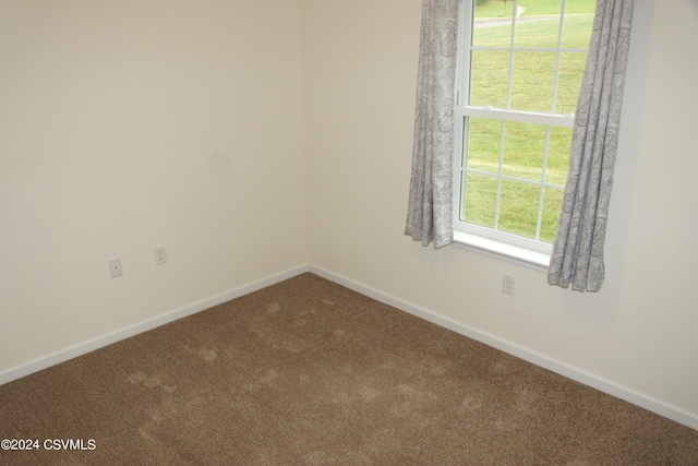 spare room with carpet and baseboards