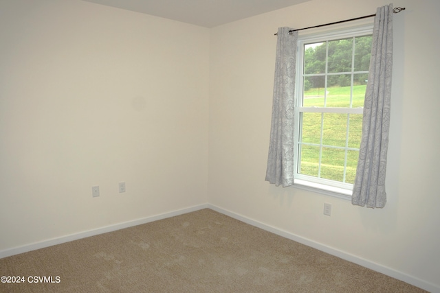 carpeted empty room with baseboards