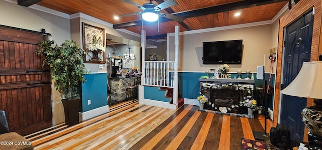 living room with crown molding, light wood-type flooring, a barn door, wood ceiling, and ceiling fan