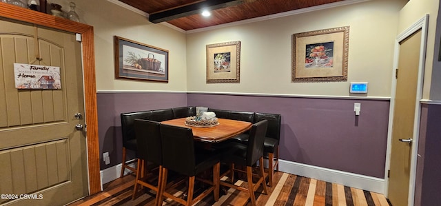 dining room featuring beam ceiling, crown molding, dark hardwood / wood-style floors, and wood ceiling