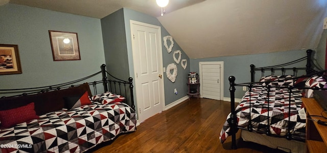 bedroom featuring dark wood-type flooring and lofted ceiling