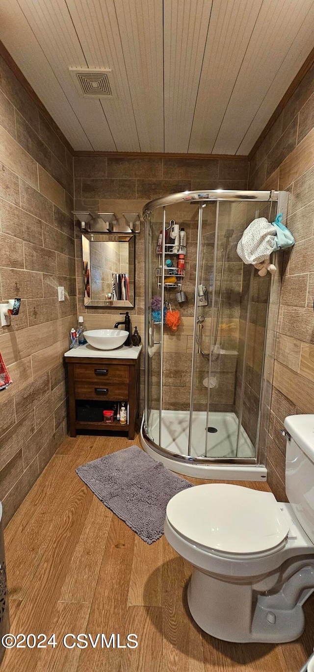 bathroom with a shower with shower door, hardwood / wood-style flooring, vanity, and toilet