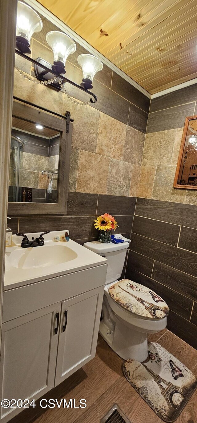 bathroom with wood ceiling, tile walls, hardwood / wood-style flooring, toilet, and vanity