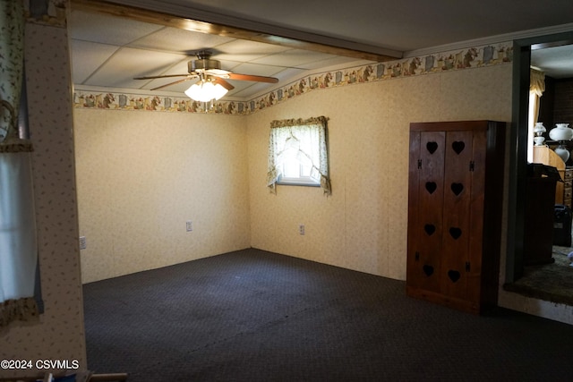 carpeted empty room featuring beam ceiling and ceiling fan