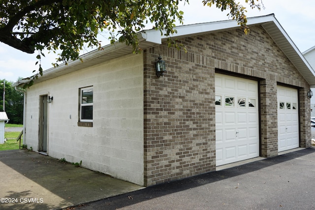 view of side of home featuring an outbuilding and a garage