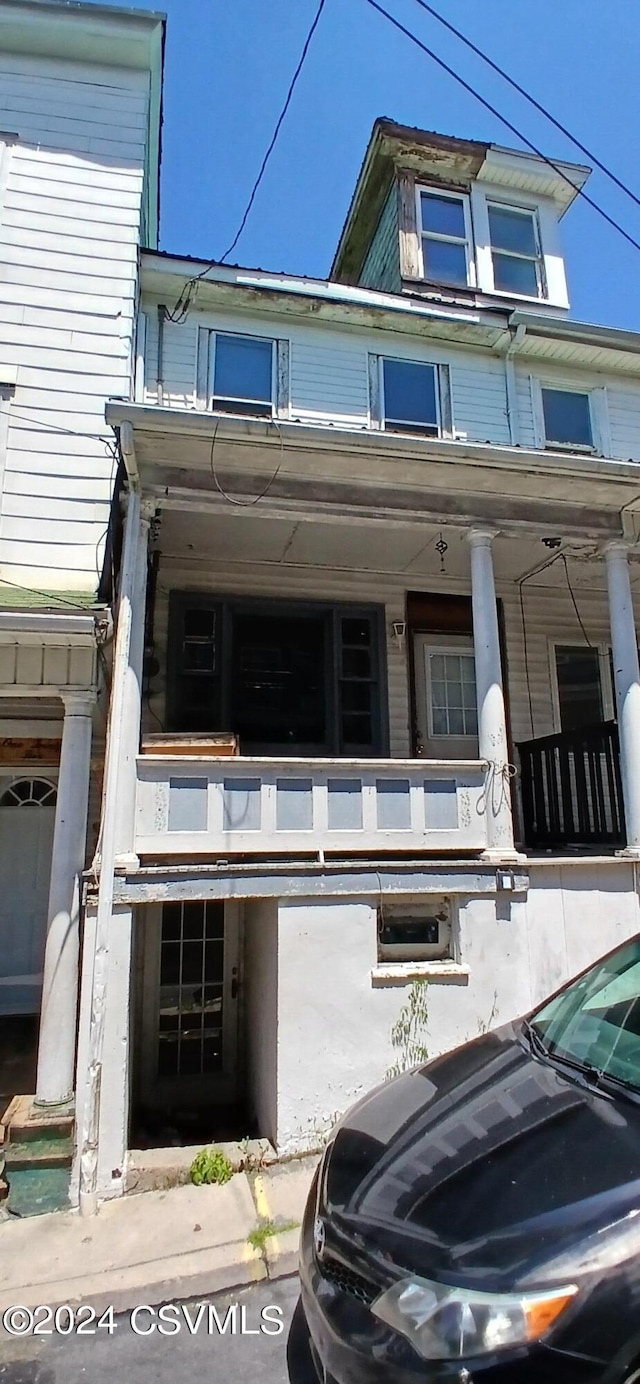 view of front of property with a balcony and a porch