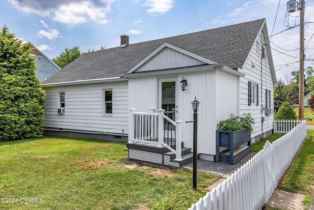 rear view of property featuring a lawn