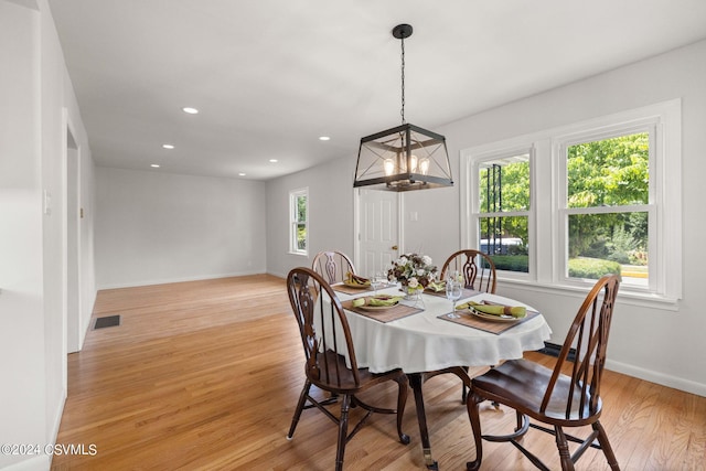 dining room with a notable chandelier and light wood-type flooring