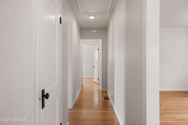 corridor with light hardwood / wood-style floors