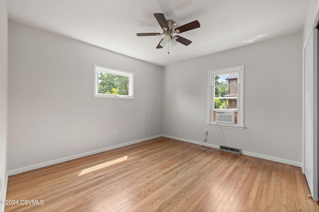 spare room with light hardwood / wood-style floors, cooling unit, and ceiling fan