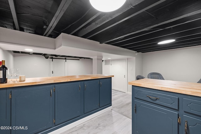 basement featuring bar and light wood-type flooring