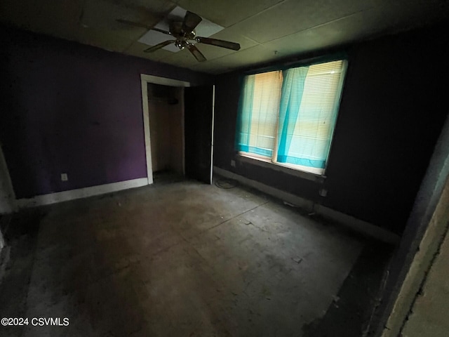 unfurnished bedroom with ceiling fan and a closet