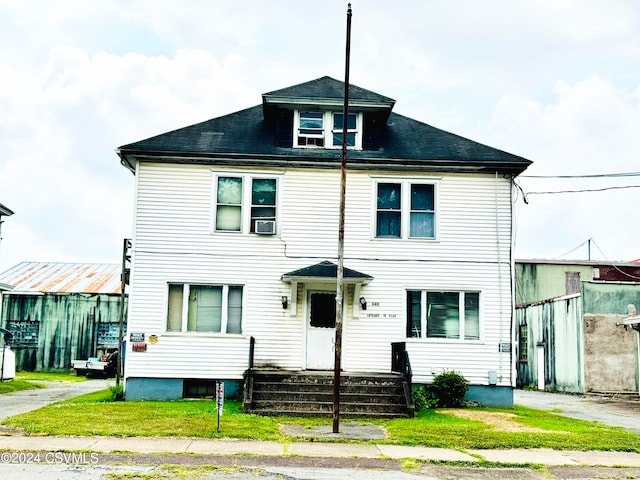 view of front of property featuring a front lawn and cooling unit