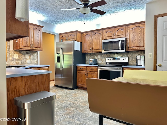 kitchen with stainless steel appliances, backsplash, a textured ceiling, light tile patterned flooring, and ceiling fan