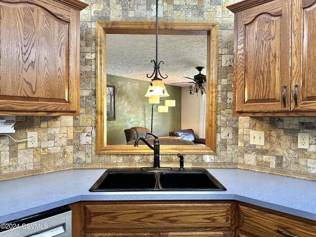 kitchen featuring white dishwasher, sink, decorative light fixtures, a textured ceiling, and ceiling fan