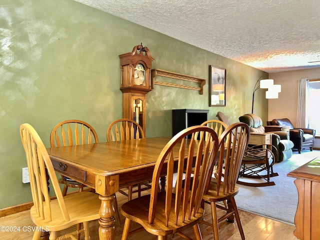 dining room with hardwood / wood-style flooring and a textured ceiling