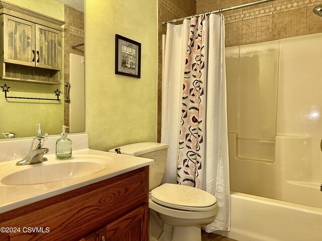 full bathroom with shower / bath combo with shower curtain, vanity, and toilet