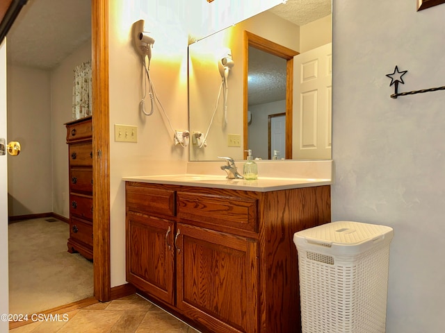 bathroom featuring vanity, a textured ceiling, and tile patterned flooring