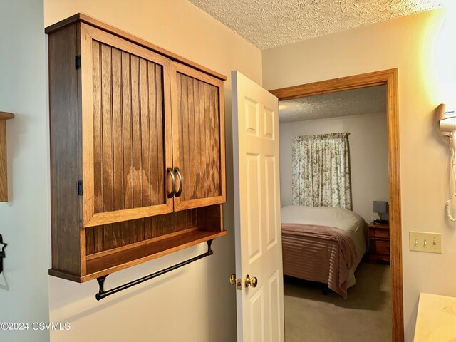 bedroom with carpet and a textured ceiling