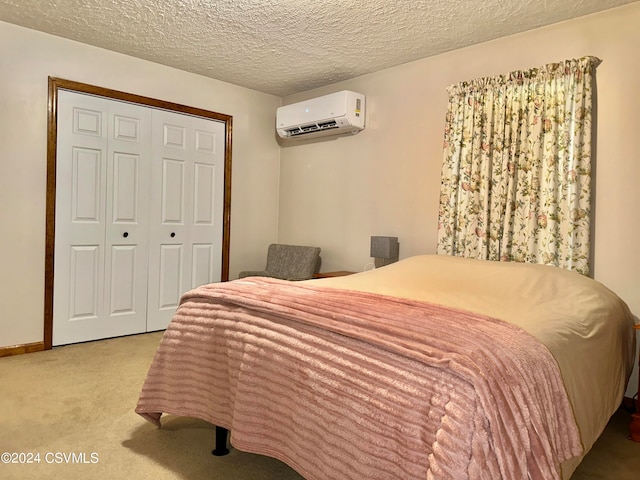 bedroom featuring a textured ceiling, a wall mounted air conditioner, a closet, and carpet