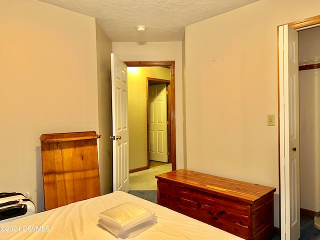 unfurnished bedroom featuring a closet, carpet floors, and a textured ceiling