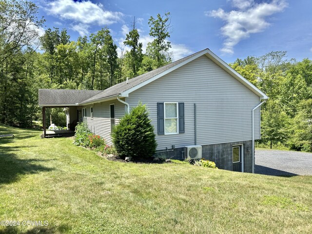 view of side of home with a yard and central air condition unit